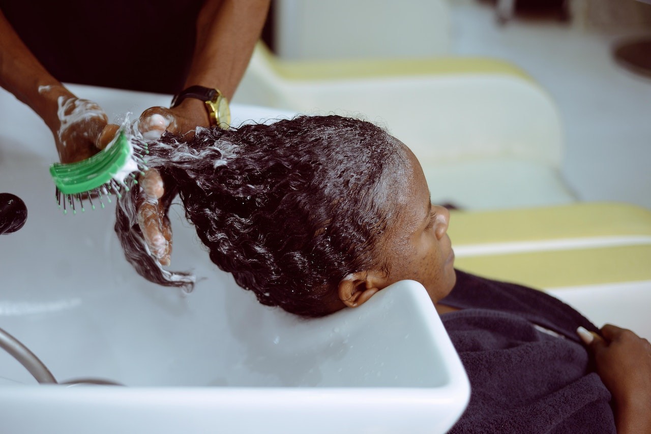 lady having hair washed at salon sink