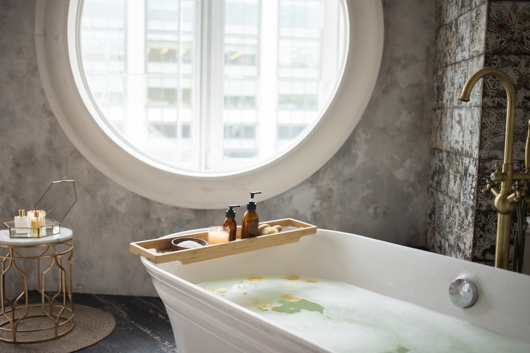 bathtub filled with water overlooking circluar window
