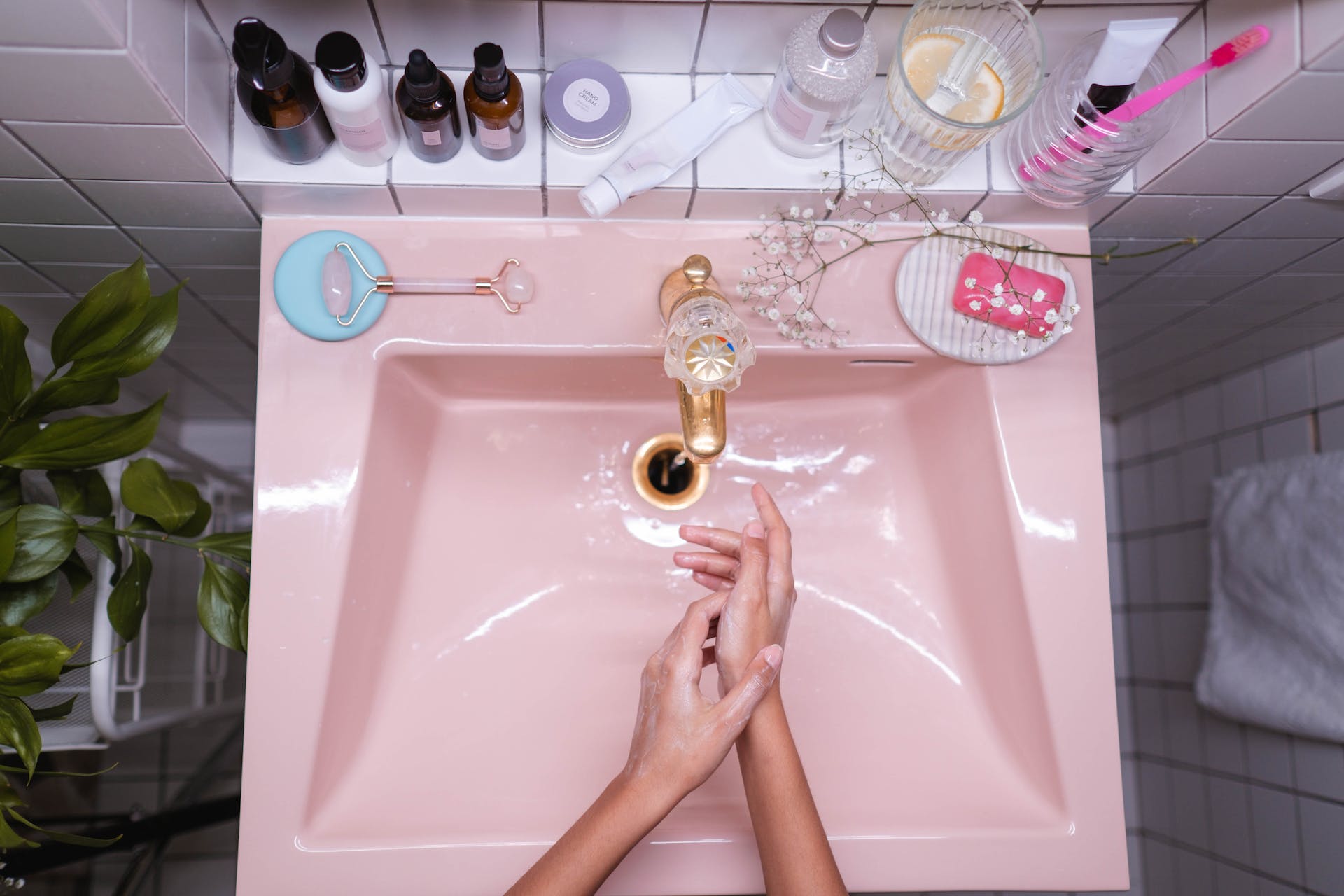 Aerial pic of a pair of hands washing up in a pink sink