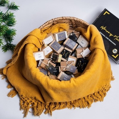 orange cloth lined, woven basket filled with assorted House of Moira bathing bars